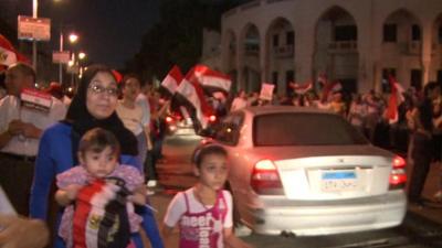 Demonstrators wave flags in Cairo