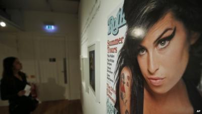 Visitor looking at Amy Winehouse memorabilia, including Rolling Stone cover