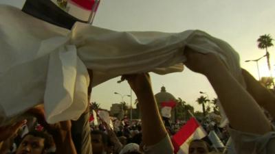 : Young Egyptian men wave death shrouds