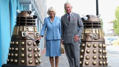 Prince Charles, Prince of Wales and Camilla, Duchess of Cornwall pose next to two Daleks as they visit BBC Roath Lock Studios on July 3, 2013 in Cardiff, Wales