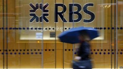 A woman walking past the headquarters of the Royal Bank of Scotland in the City of London