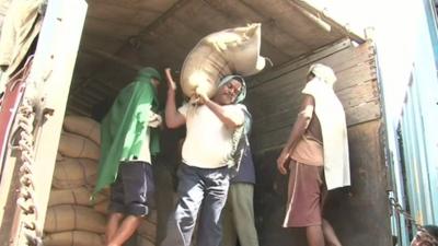 India worker unloads sack of grain
