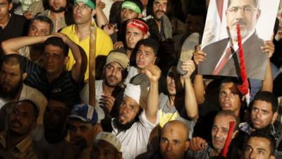 Supporters of Egypt"s ousted president Mohammed Morsi react after the Minister of Defence's announcement on state television Wednesday, July 3, 2013