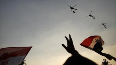 Egyptian military helicopters fly in formation over Tahrir Square in Cairo, Egypt