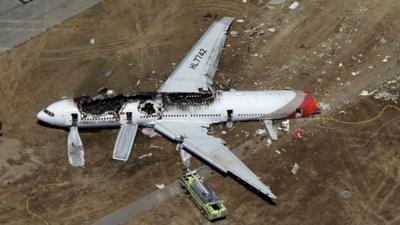 A Boeing 777 airplane lies burned on the runway after it crash landed at San Francisco International Airport