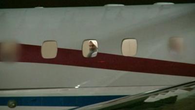 Radical cleric Abu Qatada looks out of the window of the plane