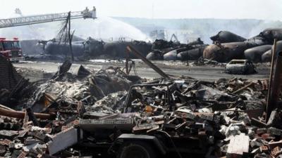 Firefighters at scene of burnt-out train wreckage