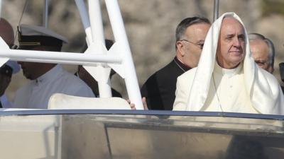 A gust of wind lifts up Pope Francis" mantle as he stands onboard a boat at Lampedusa Island, southern Italy, July 8, 2013