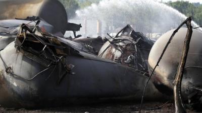 A burnt tree stands near the remains of a train derailment in Lac Megantic, Quebec