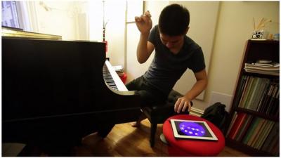 Conrad Tao playing the piano and ipad