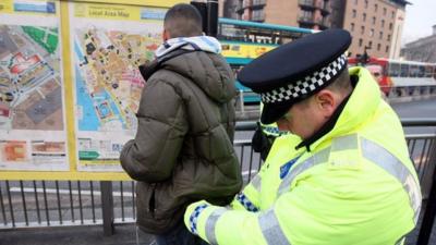 Police officers, combating potential knife-crime, stop and search people arriving in Liverpool by bus