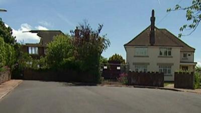 Damaged house beside house for sale