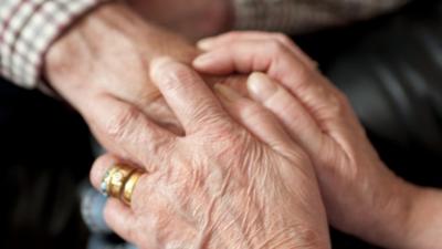 Carer holding an elderly patient's hand