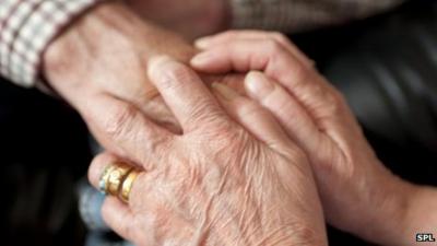 Carer holding an elderly patient's hand