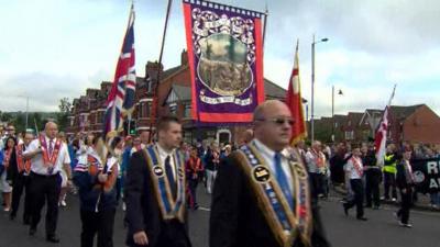 Orange parade past Ardoyne shops