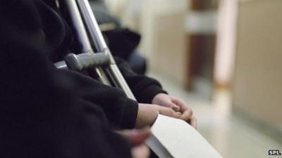 Unidentified patient with crutches holds paperwork