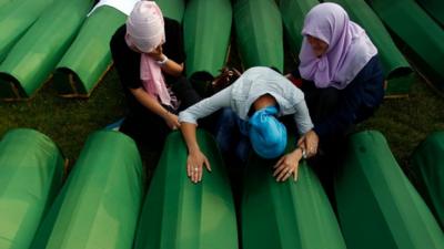 Women grieve over coffins