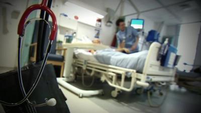 Stethoscope and patient in hospital bed