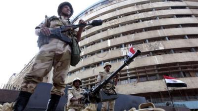 Soldiers outside the state-run television station in Cairo on 6 July 2013