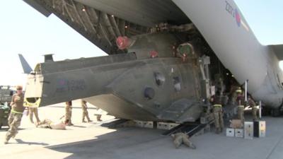 Merlin helicopter being loaded into back of am RAF C17