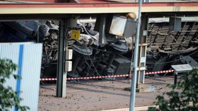 Carriages derailed in an accident lie within Bretigny-sur-Orge railway station