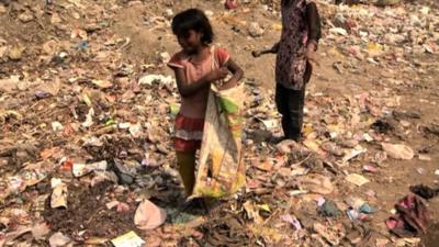 Indian girl picking up rubbish