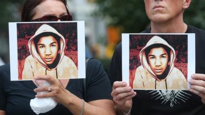 People hold photos of Trayvon Martin at a rally honouring Martin at Union Square in Manhattan on July 14, 2013 in New York City