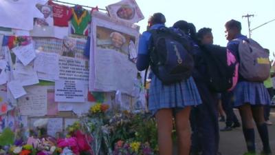 Schoolgirls look at tributes to Nelson Mandela