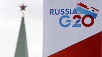 A tower of the Kremlin is seen behind a sign hanging on the Manezh Exhibition Center, venue for this week's meeting of G20 Finance Ministers