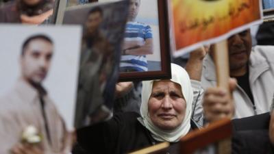 Palestinians hold pictures of their jailed relatives