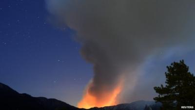 A plume of smoke rises into the night sky in southern California