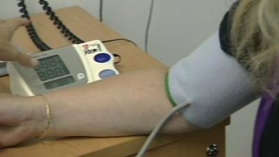 Woman having blood pressure checked