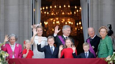 Queen Fabiola of Belgium, Princess Eleonore of Belgium, Prince Gabriel of Belgium, Queen Mathilde of Belgium ,Princess Elisabeth of Belgium, King Philippe of Belgium, Prince Emmanuel of Belgium, Prince Albert II of Belgium and Princess Paola of Belgium are seen greeting the audience from the balcony of the Royal Palace