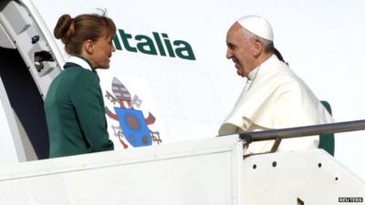 Pope Francis is welcomed by crew members as he boards a plane at Fiumicino Airport in Rome