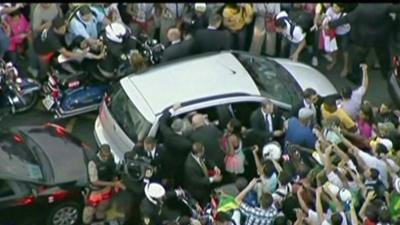 Crowds surround the pontiff's car on its way from the airport