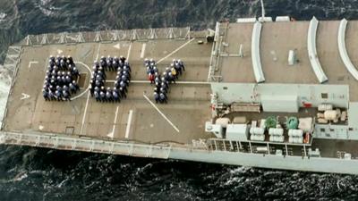 Service personnel spell out the word 'boy' on deck