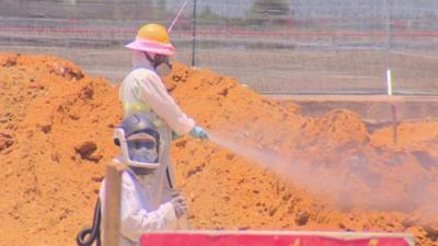 Workers in masks and protective clothing