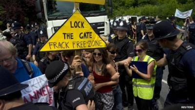 Demonstrators attempt to prevent police officers escorting a lorry to a drilling site