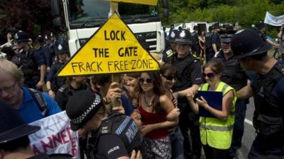 Demonstrators attempt to prevent police officers escorting a lorry to a drilling site