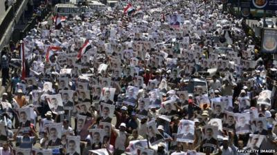 Supporters of the Muslim Brotherhood and Egypt's ousted president Mohamed Morsi carry his portrait as they demonstrate outside Rabaa al-Adawia mosque