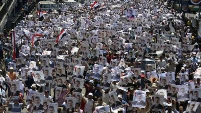 Supporters of the Muslim Brotherhood and Egypt's ousted president Mohamed Morsi carry his portrait as they demonstrate outside Rabaa al-Adawia mosque