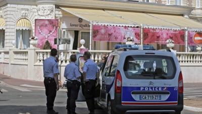 Police cars are parked outside the Carlton Hotel