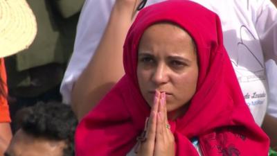 Young woman praying during Papal Mass