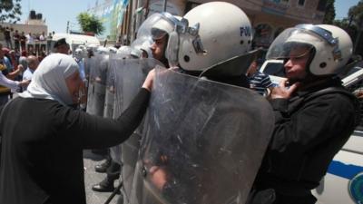 Palestinian woman and riot police