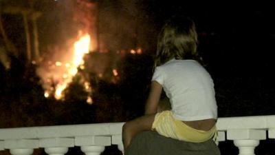 Young girl looks on at flames in Barcelona