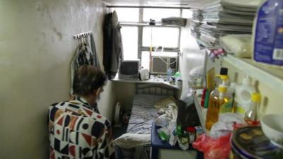 Man enters his small home in Hong Kong