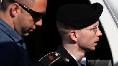 US Army Private First Class Bradley Manning is escorted by military police as arrives to hear the verdict in his military trial 30 July 2013