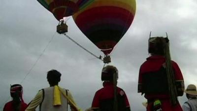 Aisikaier Wubulikaisimu walking between two air balloons
