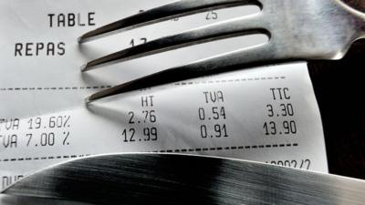 A picture taken on November 8, 2012 in a restaurant in Lille shows a fork and knife set up on a bill with the 19,60 percent value added tax (VAT)