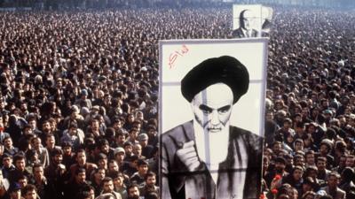 Iranian protesters hold a up a poster of Ayatollah Ruhollah Khomeini during a demonstration in Tehran